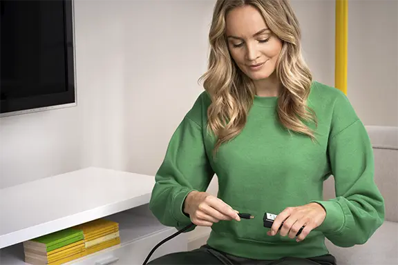 A pessoa liga o cabo ao adaptador HDMI.