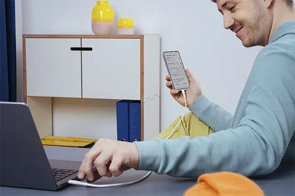 O telemóvel é ligado ao computador através de um cabo USB.